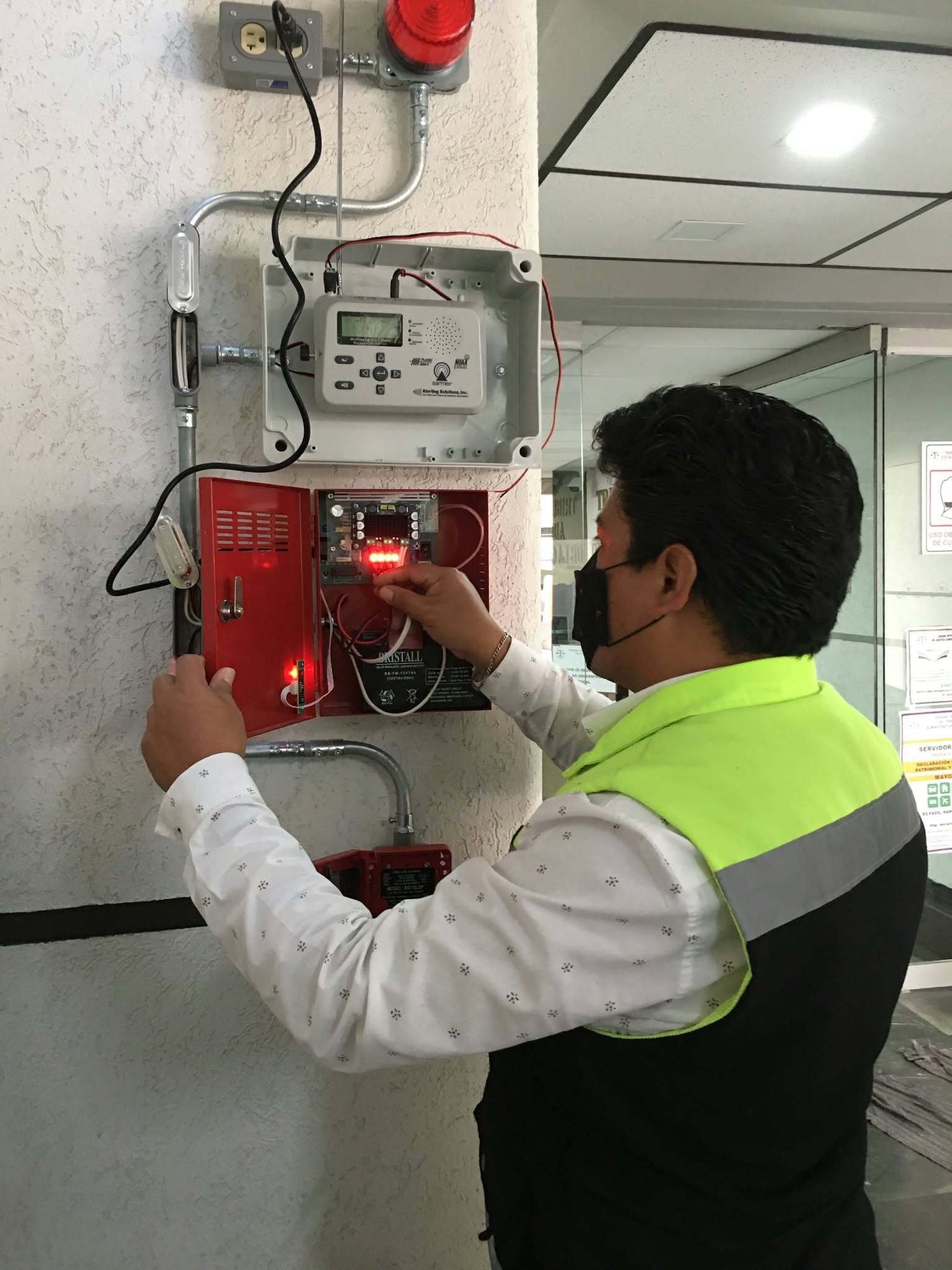 Técnico revisando el panel de un equipo de alarma.