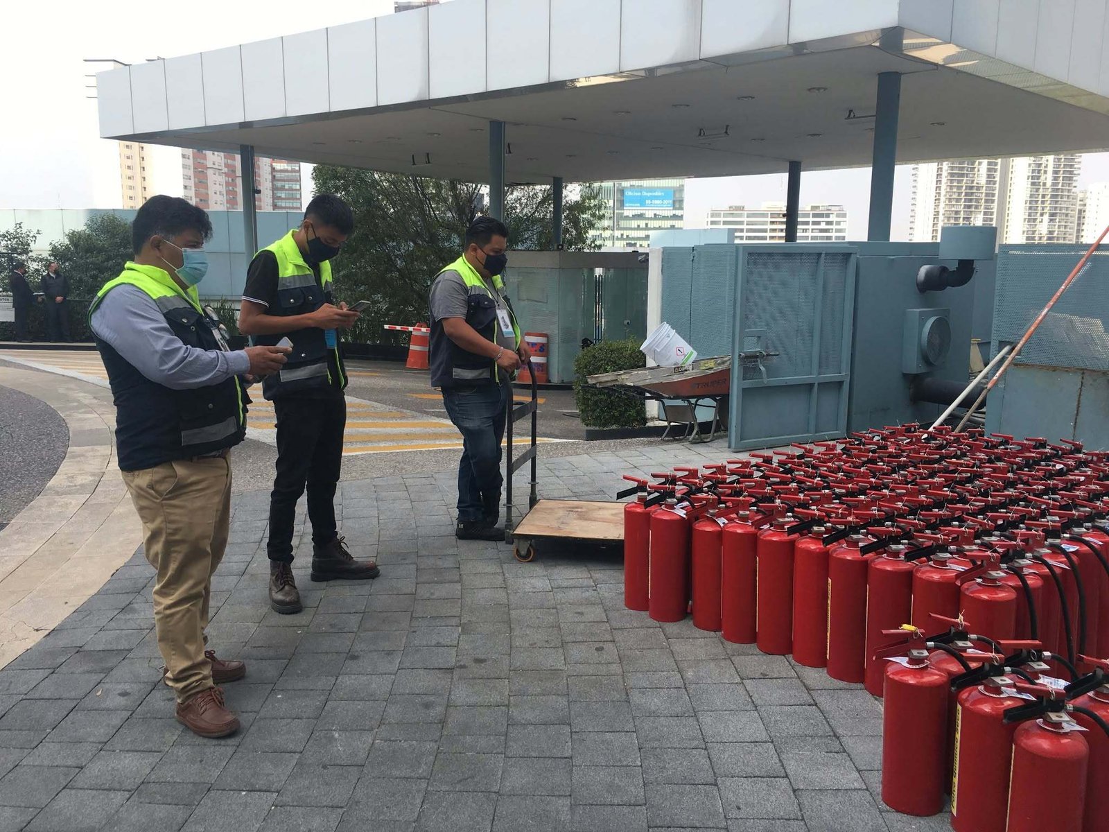 Personal de Hall Fire junto a un carrito y un grupo de extintores.